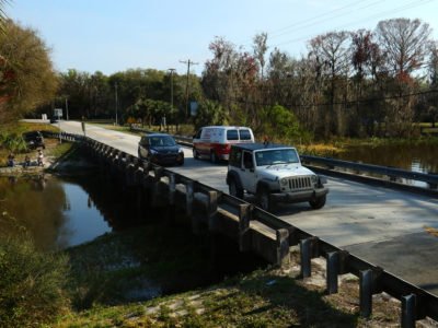 Cars drive along the Scenic Sumter Heritage Byway crosses a river near Lake Panasoffkee, Fla.
